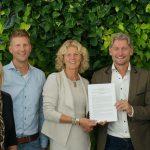 Jacco Vooijs (tweede van rechts) biedt de visie glastuinbouw van LTO Glaskracht aan burgemeester Agnes van Ardenne – van der Hoeven aan.